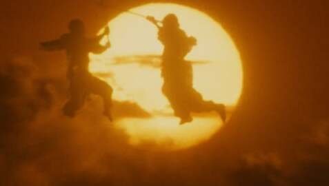 Silhouetted fighters against a blazing golden sun